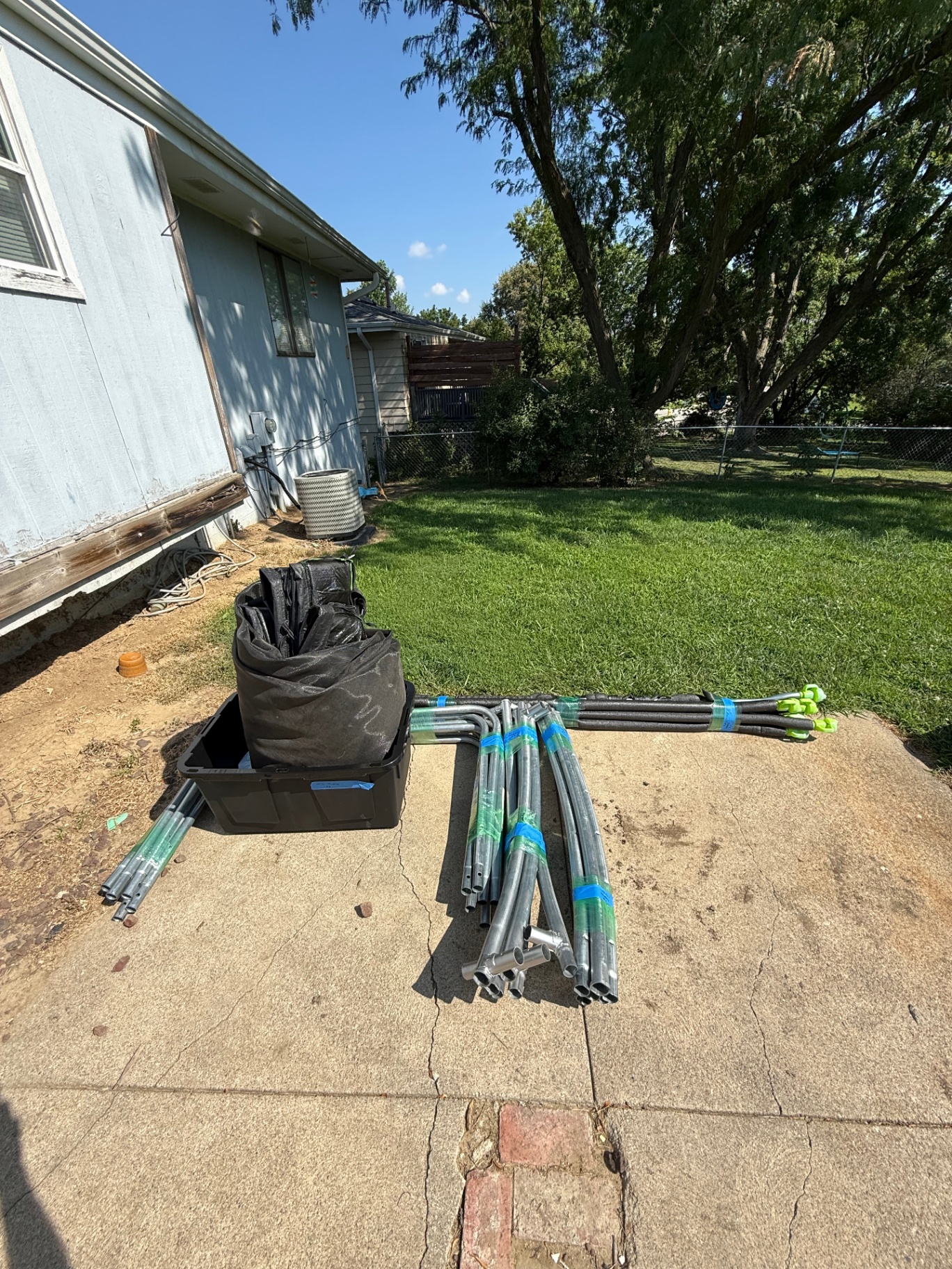 Trampoline frame parts and netting laid out on a driveway during the move