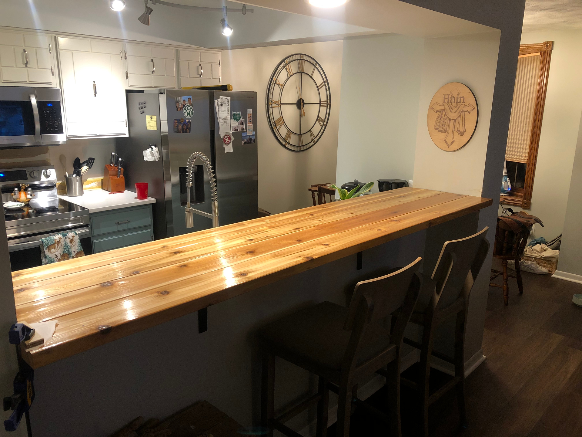 Long cedar plank bar top with a high-gloss clear finish overlooking a kitchen