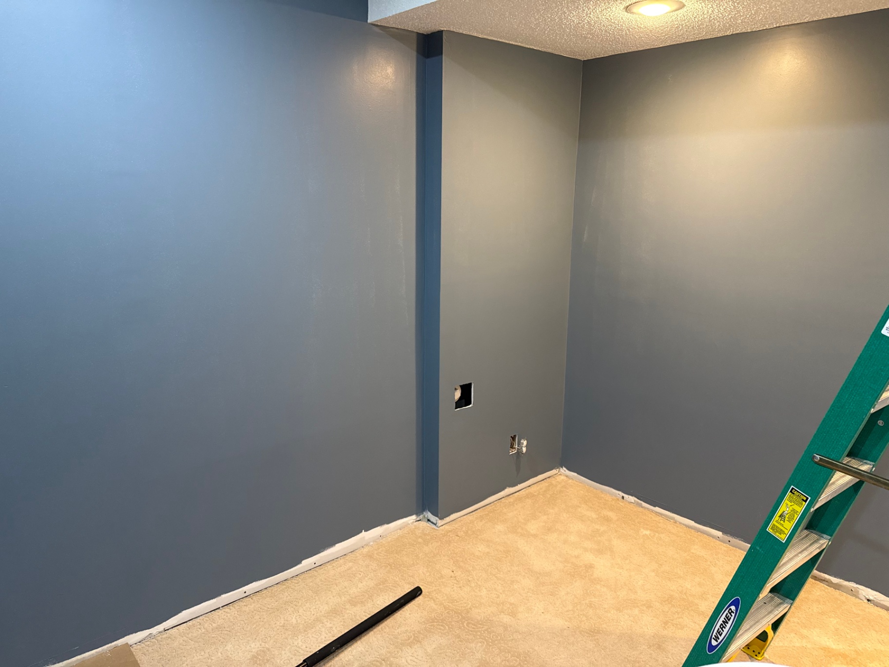 Interior room freshly painted in two shades of blue with crisp white baseboards and textured ceiling