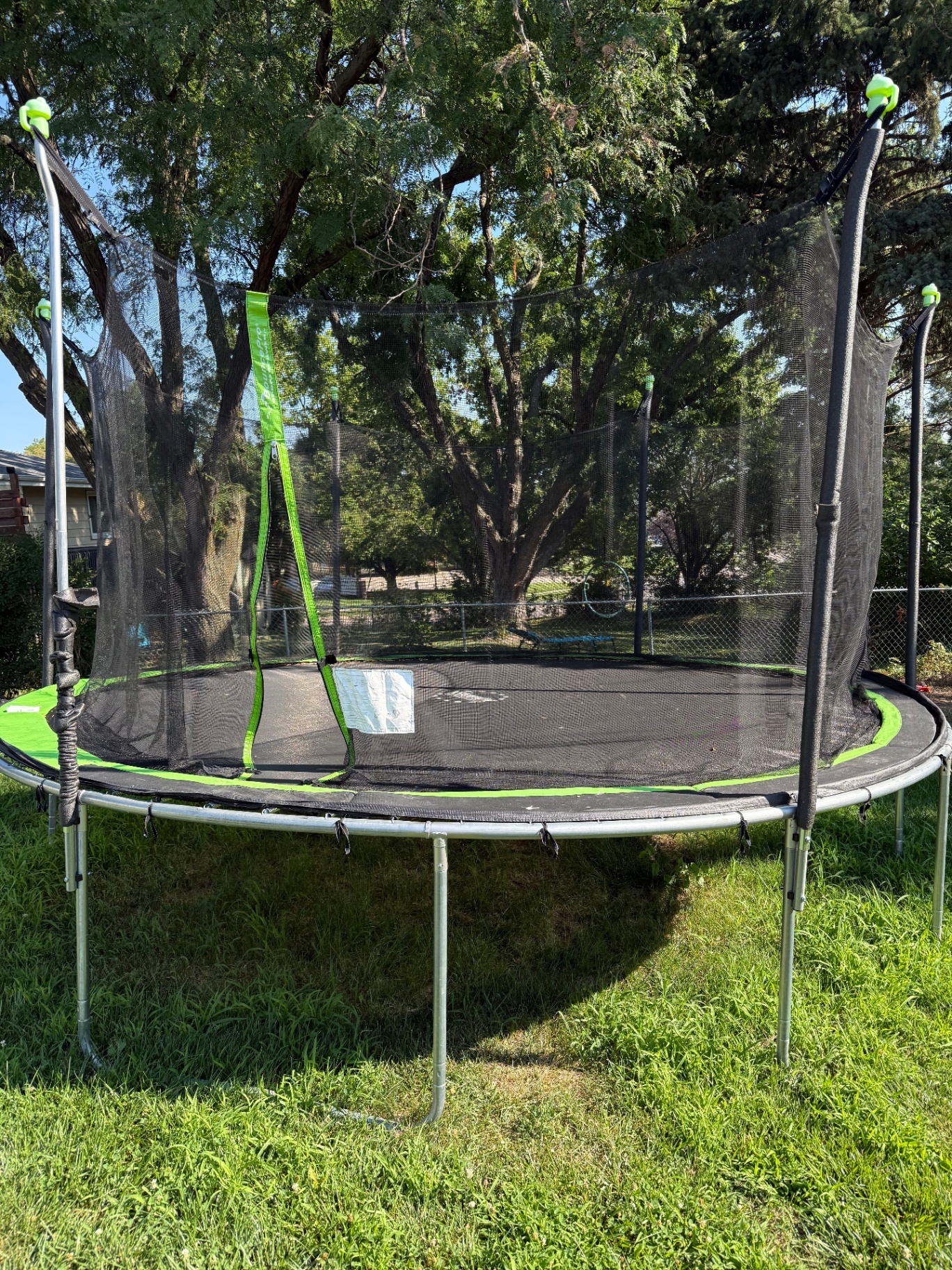 Assembled trampoline frame with enclosure poles at the original location before disassembly for the move