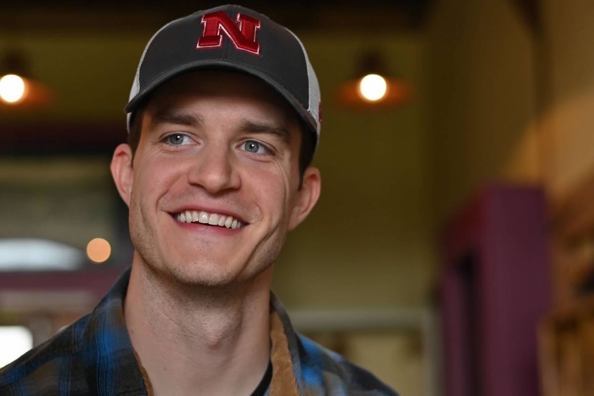 Portrait of Jake wearing a Nebraska N cap