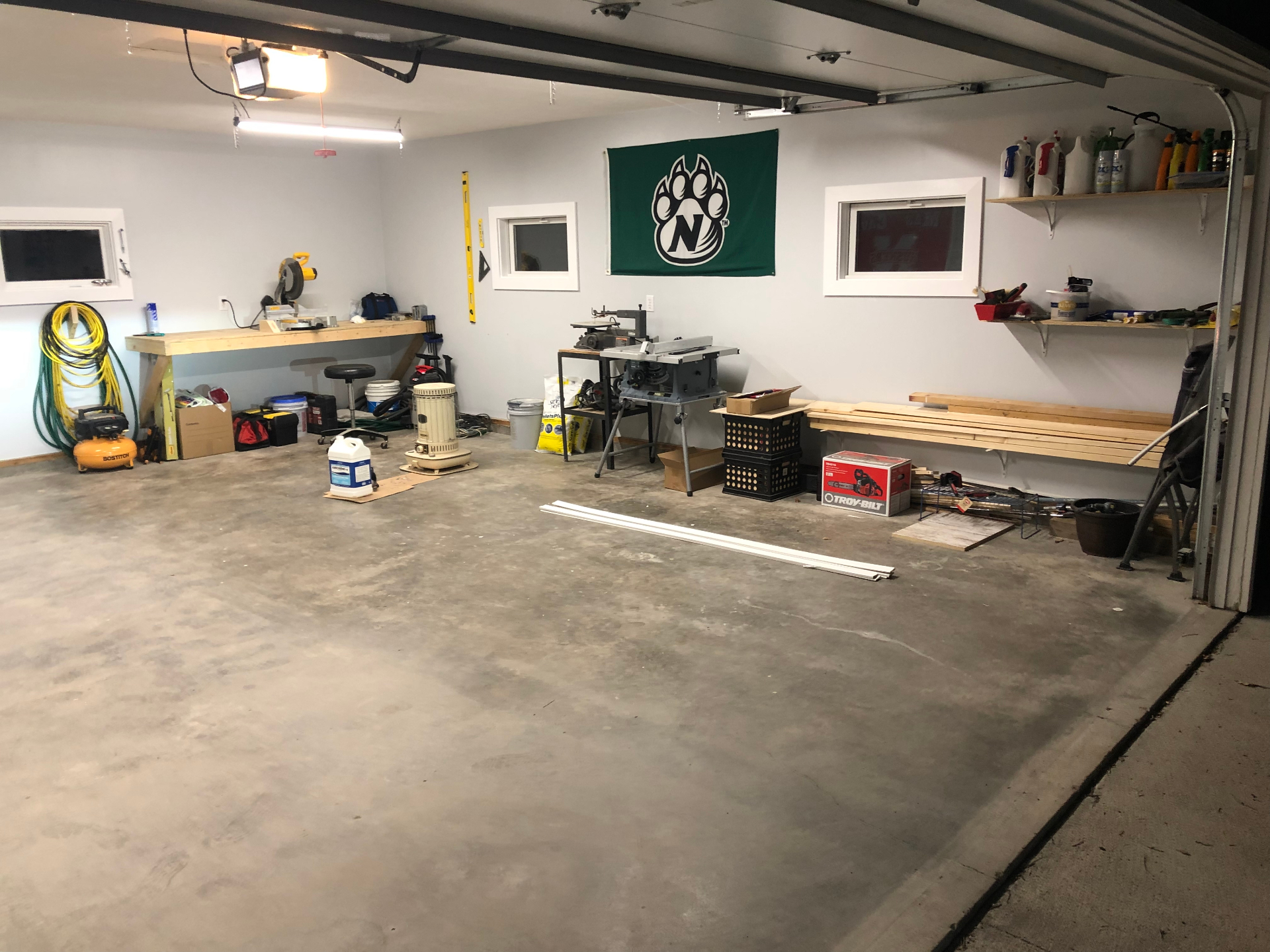 Organized garage workshop with a miter saw station, table saw, and wall-mounted shelving