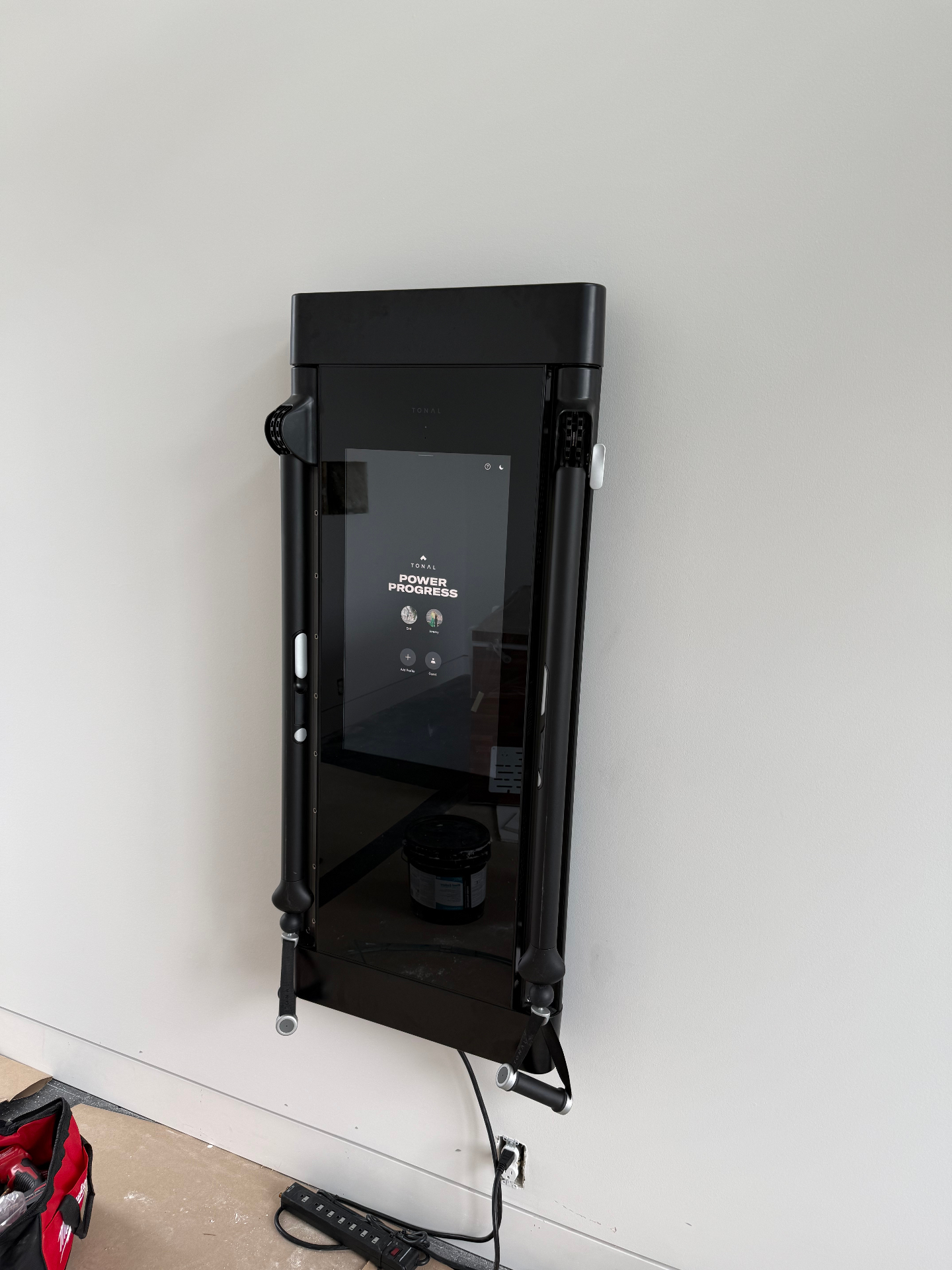 Tonal wall-mounted smart home gym installed on a garage wall, level and flush against the drywall